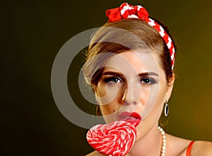 Woman eating lollipops. Girl in pin-up style hold striped candy.