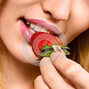 Woman eating mellow strawberry photo