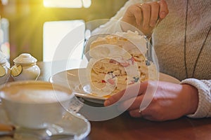 Woman eating meringue cake in the cafe