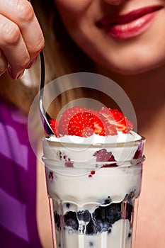 Woman eating a mixed berry parfait