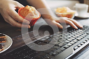 Woman eating muffin at workplace