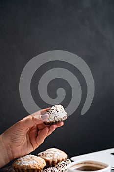 Woman eating muffin at workplace. Unhealthy snack