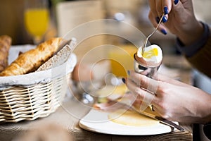 Woman eating organic boiled egg at breakfast, healthy food or lifestyle concept