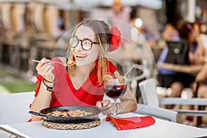 Woman eating Paella dish at the restaurant