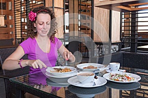 Woman eating pasta at a table in a photo