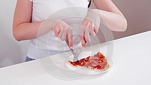 Woman eating pizza with a knife and fork on white table. Trendy isometric composition.