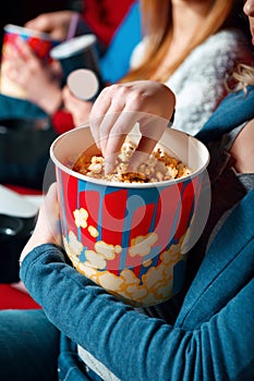 Woman eating popcorn in cinema