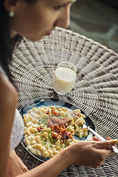 Woman eating potato dumplings with sheep cheese and bacon, traditional slovakian food, slovak gastronomy