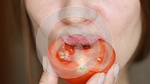 Woman Eating Red Tomato. Vegetarian food. Closeup