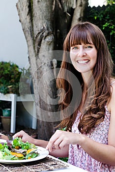 Woman eating salad, alfresco dining photo