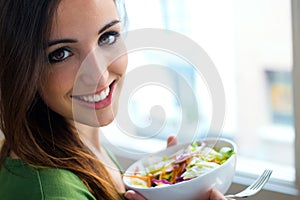 Woman eating salad. Portrait of beautiful smiling and happy Caucasian woman enjoying a healthy salad