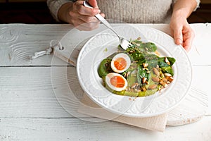 Woman eating salad with spinach, almond and eggs horizontal