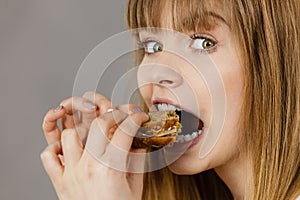 Woman eating sandwich, taking bite