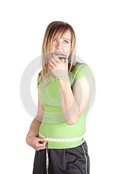 Woman eating snack and measuring waist