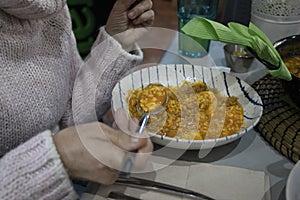 Woman eating a soupy rice. A highly demanded food in Spain