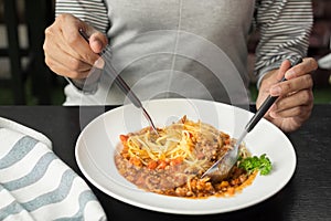 Woman eating spaghetti with tomato sauce