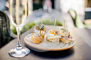 Woman eating spanish pinchos at the bar outdoors