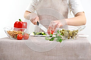 Woman eating steamed vegetable in the brown kraft paper food container on white wooden background.