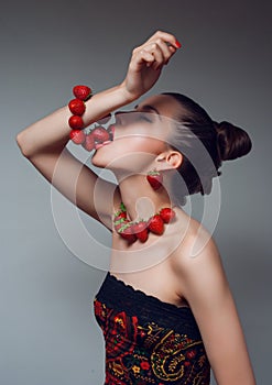 Woman eating strawberry bracelet photo