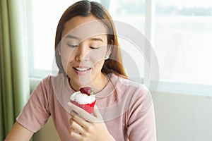Woman eating sweet cupcake on diet cheat day.