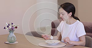 woman eating tasty dumpling in the kitchen