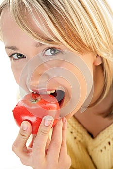 Woman eating tomato