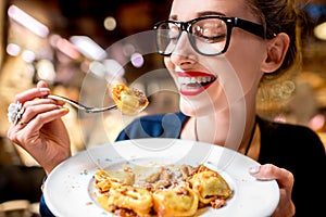 Woman eating tortellini pasta photo