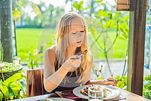 Woman eating Traditional Balinese cuisine. Vegetable and tofu st