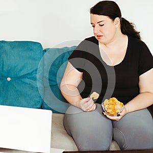 Woman eating unhealthy food watching series online