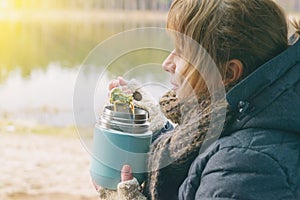 Woman is eating a warm meal from a thermos