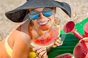 Woman eating watermelon on the beach