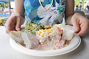 Woman eats Cook Island potato salad Mainese traditional dish s