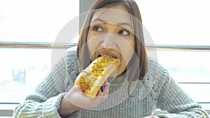Woman eats a hot dog at a fast food cafe.