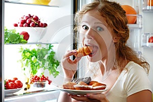 Woman eats night stole the refrigerator photo