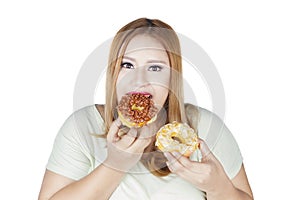 Woman eats two donuts in hand