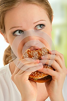 Woman eats unhealthy food, hamburger