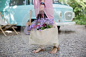 Woman with eco bag from sackcloth with pink and purple flowers