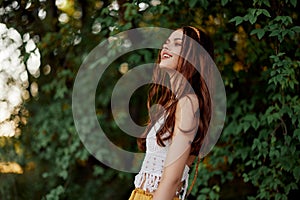 A woman in eco-friendly clothing in a hippie look dances in nature in the park and smiles at the world. The concept of