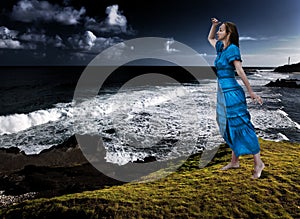 Woman on the edge of a breakaway over the storming sea