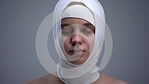 Woman in elastic headwrap with closed eyes, recovery after concussion, medicine