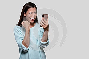 Woman elated and joyful watching and looking at smartphone while receiving good news, sms, text,  with copy space