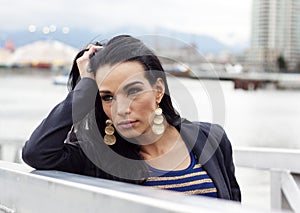 Woman with elbow on railing gazing left