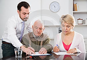 Woman and eldery man with bank employee