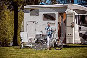 Woman on electric bike resting at the campsite VR Caravan car Va