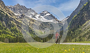 Woman on electrick Mountain bike in the Oy Tal Valley, Allgaeu Alps Below Nebelhorn