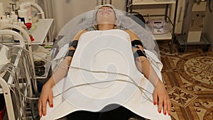 Woman with electro stimulator electrodes on her body.