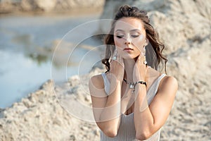 Woman in elegant dress on the beach at sunset close up portrait