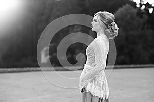 Woman in elegant evening dress walking in park or garden