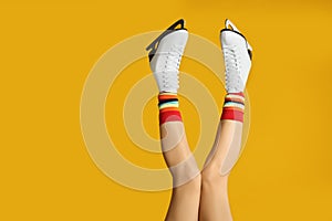 Woman in elegant white ice skates on background, closeup of legs. Space for text