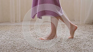 A woman elegantly drops a towel, the view of the feet close up